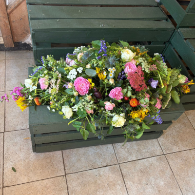 Country Garden Spray - A beautiful natural-style casket spray featuring soft seasonal colours and a graceful, garden-inspired design to honour a loved one.